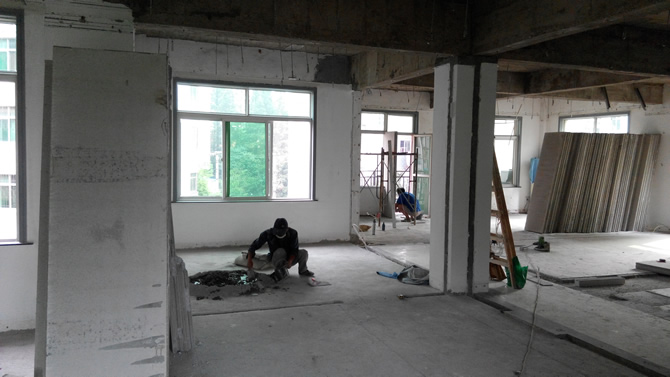 工人正在粉刷輕質墻板，對輕質墻板進行拼裝作業