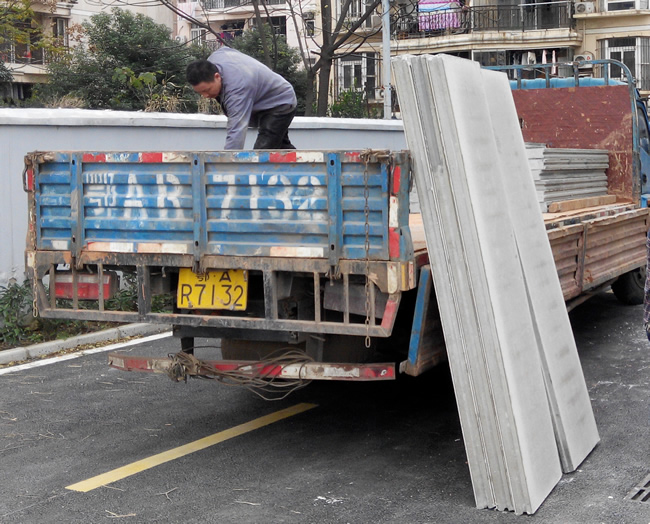 輕質(zhì)墻板運(yùn)往施工現(xiàn)場(chǎng),工人正在卸載輕質(zhì)隔墻板